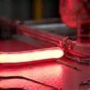 Finished neon tubes being carefully mounted and wired onto a clear backing panel